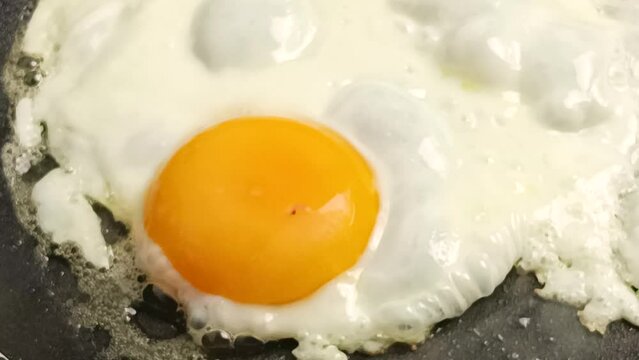 cuisson d'oeufs au plat, en gros plan, dans une po&ecirc;le