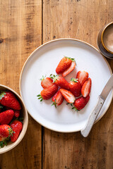 photographie culinaire d'une salade de fraise au sucre servie dans une assiette blanche