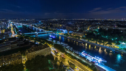 Fototapeta na wymiar Aerial night timelapse view of Paris City and Seine river shot on the top of Eiffel Tower