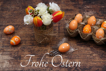 Grußkarte Frohe Ostern: Ostereier und Blumenstrauß auf altem Holzbrett mit der Beschriftung Fohe...