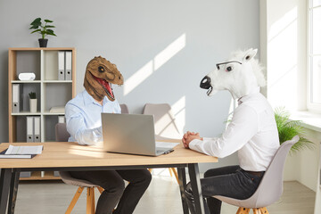 Strange people with funny, bizarre animal heads having a business meeting or a job interview. Two...
