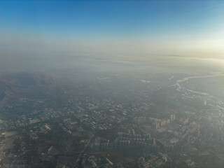 A city is seen from above with a hazy atmosphere