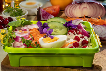 Lunch box with salads and vegetables. Fresh cabbage salad with cranberries, carrot salad in Korean....