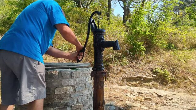 A person attempts to pump spring water, but only mud flows out. Lack of drinking water, environmental changes.