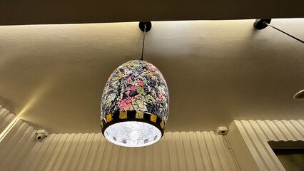 A light fixture with a floral design is hanging from the ceiling
