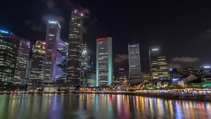 Fototapeta na wymiar Singapore quay with tall skyscrapers in the central business district on Boat Quay night timelapse hyperlapse