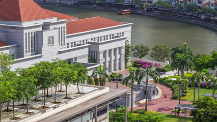 Parliament House in downtown Singapore aerial timelapse and boat quay in the background.