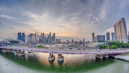 Aerial view of sunset over Helix Bridge and Bayfront Avenue with traffic timelapse at Marina Bay, Singapore