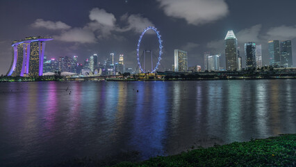 Downtown skyline of Singapore as viewed from across the water from The Garden East night timelapse....