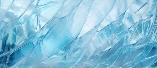 A closeup of electric blue plastic wrap resembles a frozen liquid. The pattern mimics natural landscapes with grass and twigs, creating art - obrazy, fototapety, plakaty