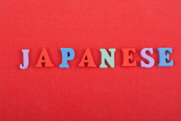 JAPANESE word on red background composed from colorful abc alphabet block wooden letters, copy...