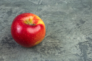 Fresh red apple on a biton background.