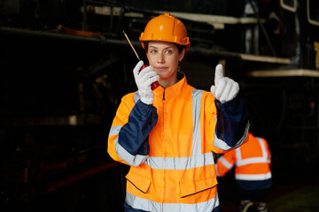 worker using walkie talkie and talking about work at construction train station