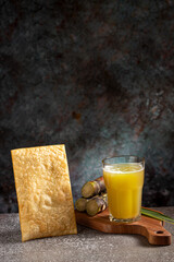 Glass of sugarcane juice with fried pastry. Typical Brazilian snack.