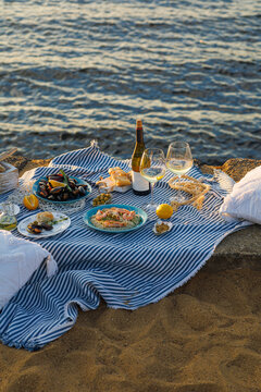 Table full of seafood and vegetable dishes with sea horizone in the background