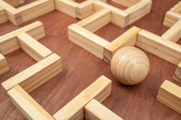 Wooden maze made with wood blocks and a wood sphere, finding labyrinth way out