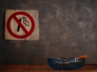 Smoking cigarette in front of no smoking sign