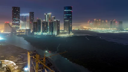 Fototapeten Buildings on Al Reem island in Abu Dhabi timelapse from above. © neiezhmakov
