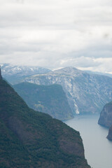 Nature view of Norwegian mountains from stegastein viewpoint on a cloudy summer day. Blue uv radiation on the mountains.