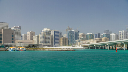 Fototapeta premium Modern buildings in Abu Dhabi skyline timelapse with mall and beach.
