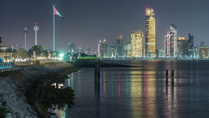 Obraz premium Panorama view of Abu Dhabi Skyline and seafront at night timelapse, United Arab Emirates