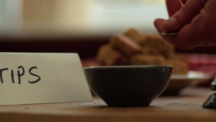 Hand leaves tips in cafe bar 