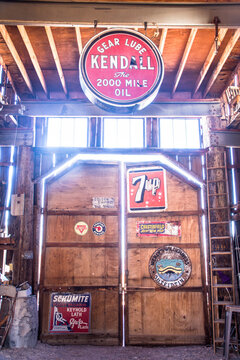 Old advertising signs hanging in deserted southwest barn - kendall oil, 7-up. Sunlight streaming through windows.