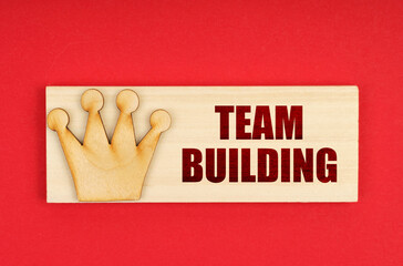 On a red surface there is a wooden block with the inscription - Team building