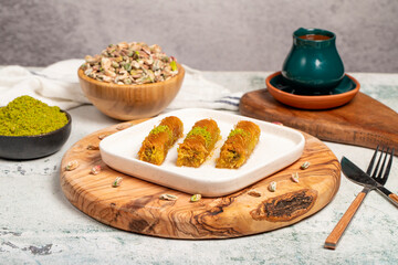 Kadayıf with pistachios on a wooden background. Turkish cuisine delicacies. Ramadan Dessert. local...