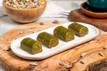 Baklava with pistachios on a wooden background. Turkish cuisine delicacies. Ramadan Dessert. local name sarma veya dürüm baklava