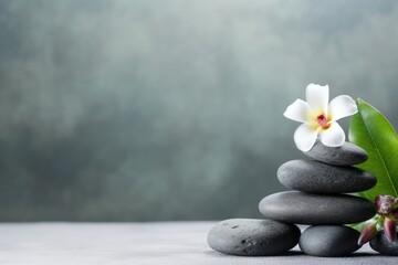 Stacked pebble stones and flowers on light background. Copy space