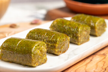 Baklava with pistachios on a wooden background. Turkish cuisine delicacies. Ramadan Dessert. local name sarma veya dürüm baklava