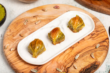 Mussel baklava with pistachios on a wooden background. Turkish cuisine delicacies. Ramadan Dessert. local name midye baklava