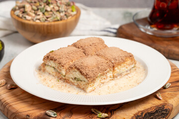 Cold baklava with pistachios on a wooden background. Turkish cuisine delicacies. Ramadan Dessert. local name soğuk baklava