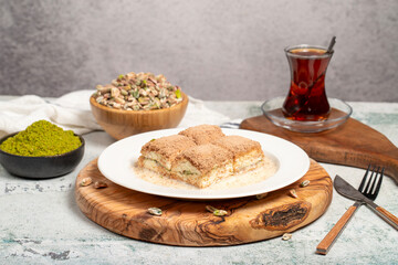 Cold baklava with pistachios on a wooden background. Turkish cuisine delicacies. Ramadan Dessert. local name soğuk baklava