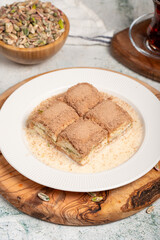 Fototapeta na wymiar Cold baklava with pistachios on a wooden background. Turkish cuisine delicacies. Ramadan Dessert. local name soğuk baklava