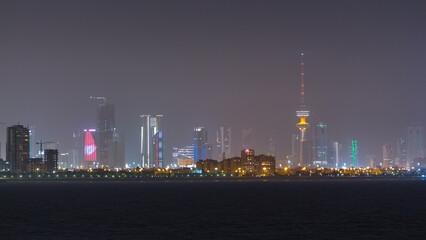 Skyline with Skyscrapers night timelapse in Kuwait City downtown illuminated at dusk. Kuwait City, Middle East