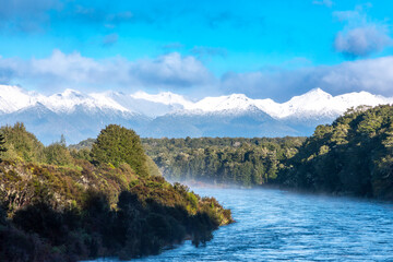 Photograph of the Waiau River from the Kepler Track swing bridge with snow-capped mountains in the background in Fiordland near Te Anau on the South Island of New Zealand