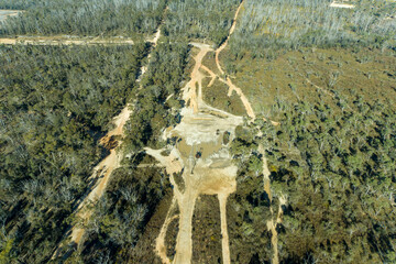 Drone aerial photograph of telephone lines and a dirt track running through a large forest affected by bushfire in the Central Tablelands of New South Wales in Australia