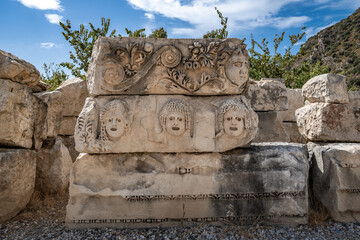 Stone masks at the ancient theatre of Myra in Demre, Antalya province of Turkey.. - 756714625