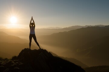 Woman stretches into yoga pose on a mountain at sunrise