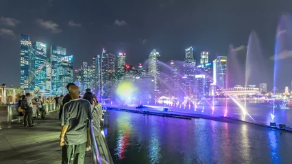 Wandcirkels aluminium Light and Water Show along promenade in front of Marina Bay Sands timelapse © neiezhmakov