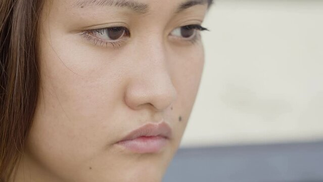 pensive sad young Asian woman closeup portrait: depressed young woman portrait 
