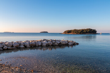 Panoramic view of small islands seen from pebble beach in coastal town Funtana, Istria, Croatia....