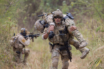 Soldier carried the injured fellow  from the mission in the forest