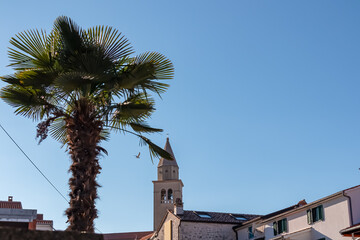 Obraz premium Scenic view of parish church of Saint Bernard in city centre of coastal town Funtana, Istria, Croatia. Adriatic Mediterranean architecture. Travel destination concept in summer. Tourism. Blue sky