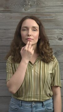Person practicing EFT. Female tapping chin (CH) meridian point. Vertical video.