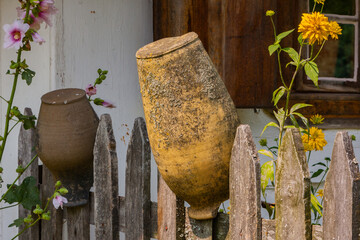Clay brown jugs on a rural fence - 756719633
