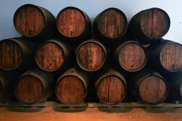Fotobehang Barrels for whiskey or wine stacked in the cellar © KikoStock