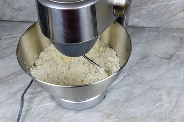 Kneading dough in a modern food processor on a kitchen table